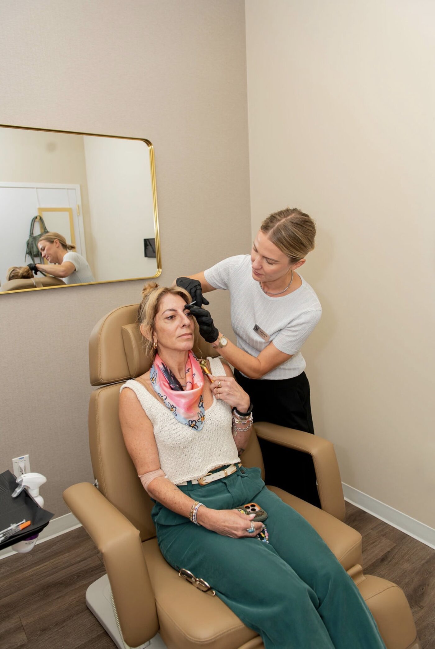 Lindsey Strelecki performing a skin treatment on a patient in a treatment room at Manor in Fort Worth