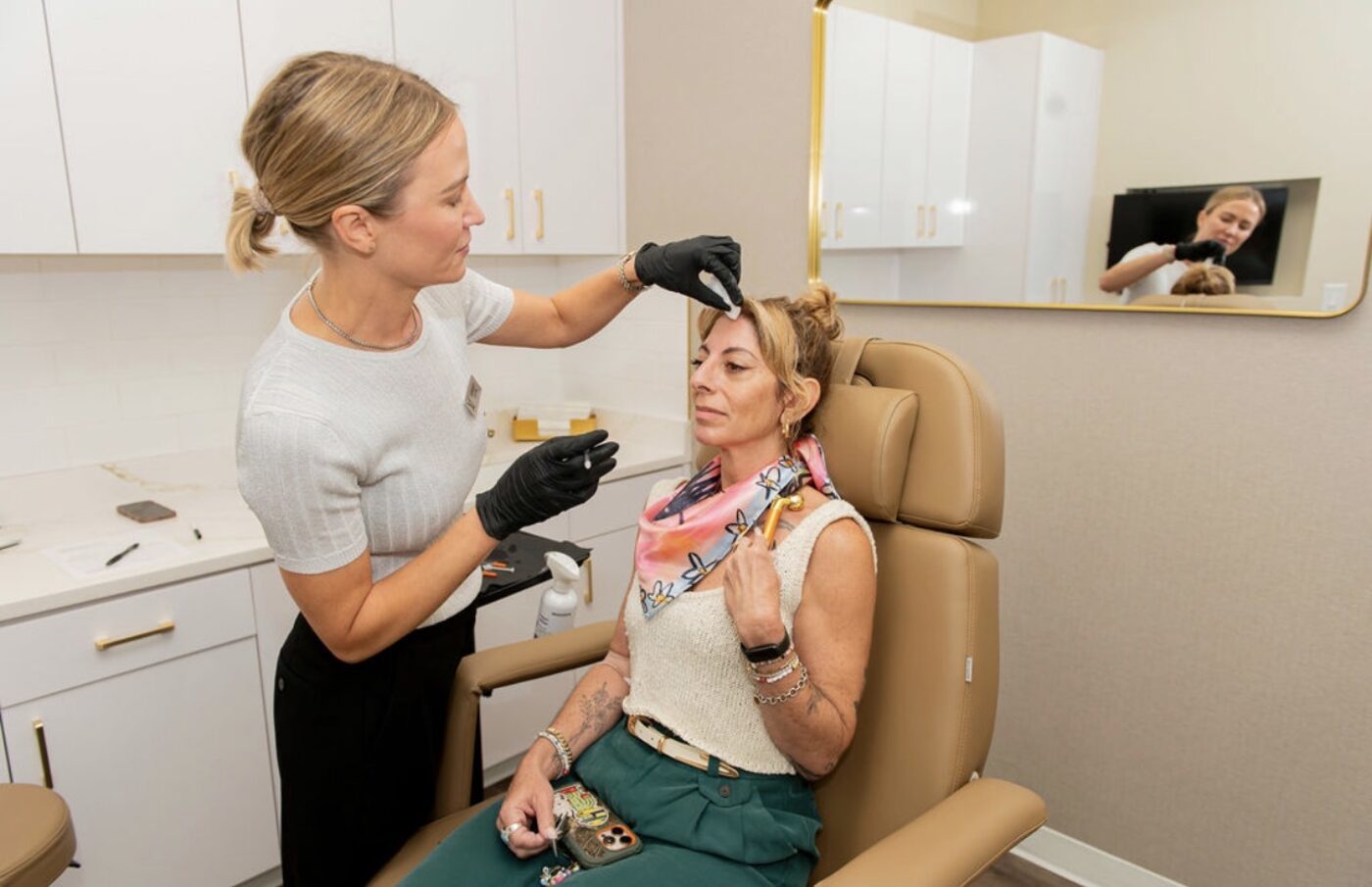 Lindsey Strelecki, RN, BSN, injecting a neuromodulator near a patient’s brow in a treatment room at Manor in Fort Worth